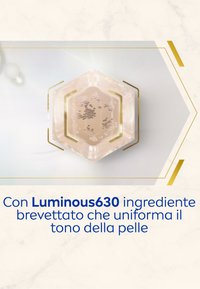 Contenitore esagonale con un interno translucido di colore pesca, decorazioni dorate e particelle fluttuanti, contenente l'ingrediente Luminous630.