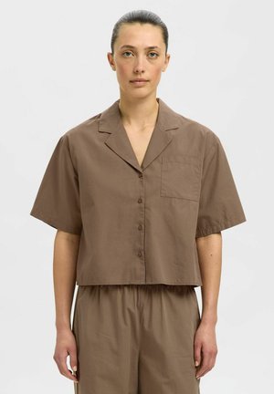 Braunes kurzärmliges Cropped-Shirt aus einem leichten Stoff, mit spitzem Kragen, vorderer Knopfverschluss und einer Brusttasche.