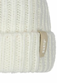 Bonnet blanc tricoté avec un design côtelé et un revers, avec une étiquette en cuir beige portant l'inscription "BARTS" en relief blanc.