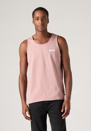 Helles rosa Baumwoll-Tanktop mit Rundhalsausschnitt, Levi's-Logo in Weiß und lockerer Passform. Getragen mit dunklen Jeans.
