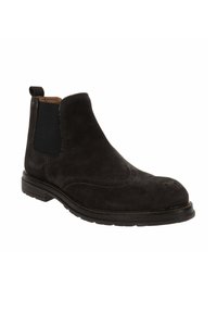 Stivali Chelsea neri in suede con pannelli elastici laterali, punta rotonda e dettagli brogue. Suola in gomma spessa con cuciture a contrasto.