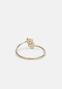 Gouden ring met een gladde, dunne band en twee hartvormige accenten, waarvan er één is versierd met een kleine edelsteen.