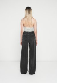 Hoge taille, wijde spijkerbroek van zwart denim met een gestructureerde afwerking en een vijf-pocket ontwerp, met een klein label aan de achterkant.