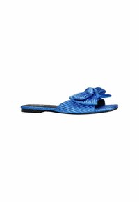 Blauwe slip-on sandaal met een gestructureerd, ribbelpatroon en een grote strik op de teen. Heeft een platte zwarte zool.
