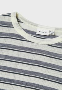 T-shirt rayé en crème avec des rayures gris foncé et bleu clair. Encolure ronde avec bordure côtelée. L'étiquette indique "name it" et taille 92. Texture douce.