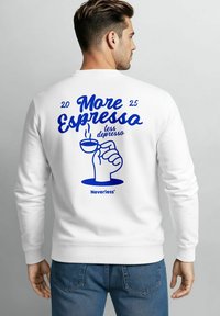 Weißes Sweatshirt mit blauem Grafiktext "Mehr Espresso weniger Depresso", einer Hand, die eine Kaffeetasse hält, und dem Markennamen "Neverless®".