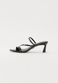 Mustad nahast sandaalid avatud varvastega disainiga, millel on mitu ristatud rihma ja 3-tolline stiletto konts. Sile tekstuur.