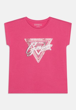 Lyserød t-shirt med korte ærmer, sølv palietter i trekantet design og "Guess"-logo midt på fronten.