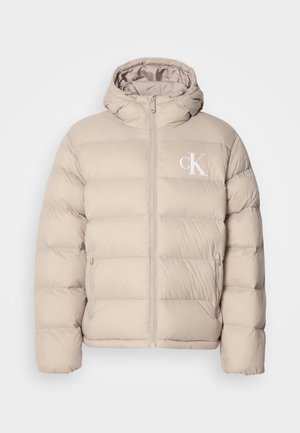 Beige Steppjacke mit Kapuze, ausgestattet mit einem gesteppten Design, zentralem Reißverschluss und einem kleinen weißen Logo auf der linken Brust. Weiches, glattes Material.