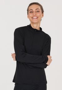 Black long-sleeve top with a high collar and half-zip closure; made from a smooth, stretchy material; fitted design and seamless cuffs.