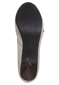 Chaussure en daim beige avec une semelle noire lisse. Présente un bout arrondi et un talon légèrement surélevé. Détail de la doublure intérieure notable visible.