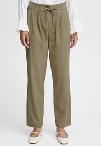 Olivovo zelené, vysoké nohavice s plisovaným predným dielom, viazaním v páse a širokým strihom. Obsahujú jediný gombík na zapínanie a textúrovanú tkaninu.