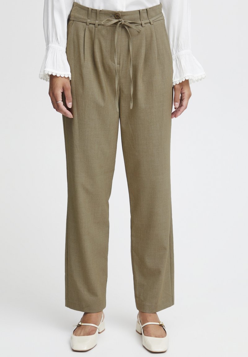 Olivovo zelené, vysoké nohavice s plisovaným predným dielom, viazaním v páse a širokým strihom. Obsahujú jediný gombík na zapínanie a textúrovanú tkaninu.