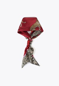 Silkescarf med en vinröd överdel och djurmönstrade accenter, samt ett beige och svart leopardmönster i ändarna, knuten i en knut.