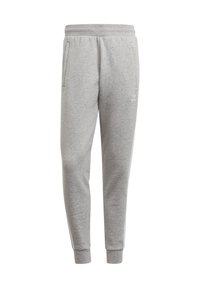 Pantalones de chándal grises, confeccionados en una tela suave, con un corte ajustado, cinturilla elástica, dos bolsillos laterales y detalles de franjas blancas.