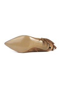 Chaussure à talon haut en suède beige, à bout pointu, avec des détails frangés texturés et une semelle beige brillante. Présentant un design élégant et épuré.