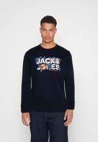 Sudadera navy de manga larga, con un estampado gráfico de "JACK & JONES" en blanco y naranja sobre un diseño de mapa azul.