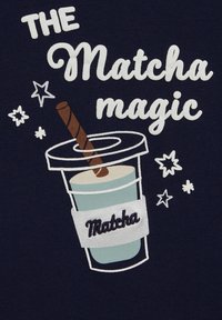 Matcha ital grafika sötétkék háttérrel; világoskék bögre, barna szívószál, ezüst címke és fehér szöveg csillagokkal körülvéve.