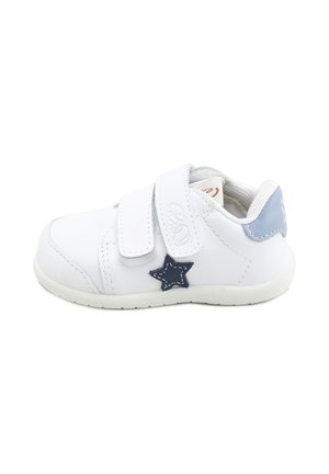 Zapatilla blanca para niño pequeño con doble cierre de velcro, detalle de estrella azul en el lateral y lengüeta de talón azul claro, mostrada de perfil.