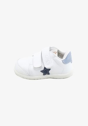 Zapatilla blanca para niño pequeño con doble cierre de velcro, detalle de estrella azul en el lateral y lengüeta de talón azul claro, mostrada de perfil.