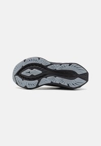 Semelle de chaussure de sport noire avec une surface en caoutchouc gris texturé, dotée de profondes rainures et d'un motif en forme de feuille pour une meilleure adhérence.