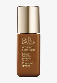 Bottiglia di vetro marrone con tappo dorato, testo in rilievo che include "Estée Lauder" e "Advanced Night Repair", con un design minimalista.