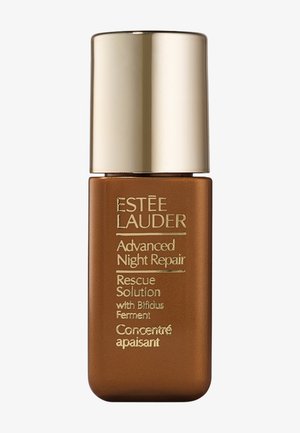 Botella de vidrio marrón con una tapa dorada, texto en relieve que incluye "Estée Lauder" y "Advanced Night Repair", con un diseño minimalista.