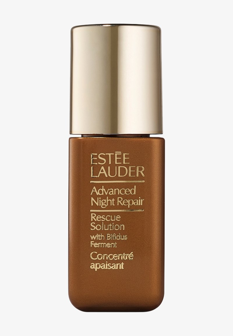 Bouteille en verre brun avec un capuchon doré, texte en relief comprenant "Estée Lauder" et "Advanced Night Repair", présentant un design minimaliste.