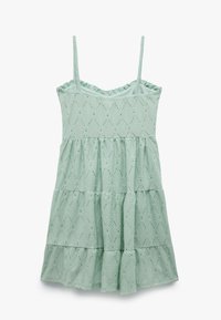 Abito senza maniche verde menta con design a strati, tessuto testurizzato, motivi a diamante e piccoli ritagli sparsi.