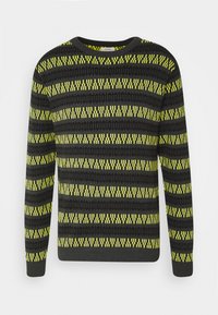 Sort og gul mønstret sweater med rund halsudskæring, lange ærmer og et geometrisk design med vandrette linjer og kontrasterende farver.