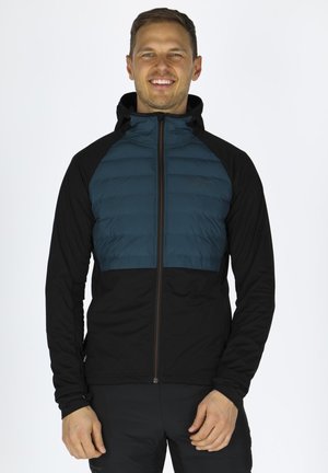 Giacca imbottita con parte superiore teal e base nera, chiusura con zip e cappuccio. Il materiale testurizzato aggiunge isolamento e flessibilità.