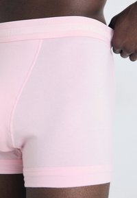Roze katoenen trunks met een zachte tailleband met reliëf "Calvin Klein" branding. Glad textuur en getailleerd ontwerp zonder zichtbare patronen.