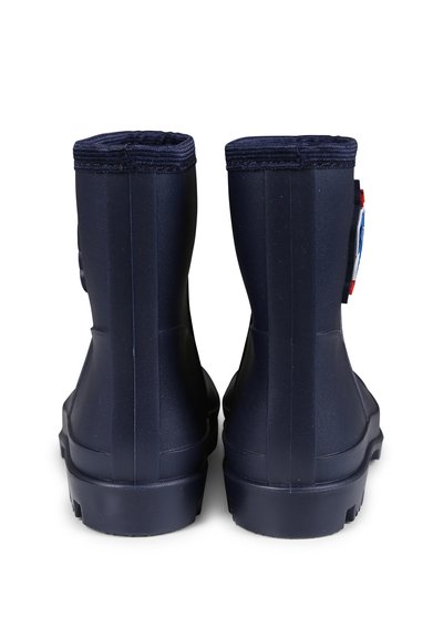 Bottes en caoutchouc navy avec une texture lisse, des bords arrondis et un petit logo. Présentent une semelle robuste pour une bonne traction.