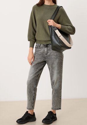 Oliivinvihreä neule, löysä malli, jossa ribbireunukset, yhdistetty vaaleanharmaisiin korkeavyötäröisiin farkkuihin ja mustiin urheilujalkineisiin. Musta laukku, jossa vaalea olkahihna.