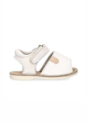 Sandalia de cuero blanco con tira de velcro, parte trasera abierta y punta redonda. Presenta un acento de cuero beige y parte superior texturizada, suela plana.