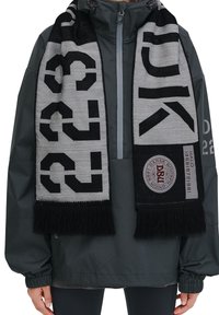 Sorte og grå tørklæde med fremtrædende sorte tal og tekst, fransede kanter og et rundt logo-patch, lavet af et blødt tekstureret stof.