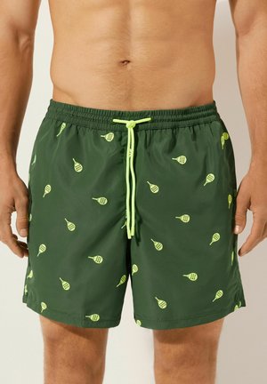 Grüne Badeshorts aus leichtem Material, mit einem Kordelzug und einem wiederholten Muster aus gelb-grünen Paddeln.