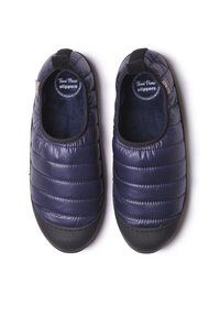 Pantofole blu navy con un design trapuntato, dotate di una morbida fodera interna, suola in gomma nera e dettagli elastici ai lati per una vestibilità confortevole.