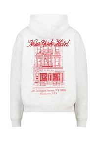 Sudadera con capucha gris que presenta un gráfico rojo de la fachada de un hotel con el texto "Hotel Nueva York" y los detalles de la dirección debajo del diseño.