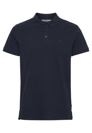 Tumed sinine polo särk, mis on valmistatud puuvillast. Omab kraed, kahe nupuga lukku ja väikest tikandiga logot rinnal. Lühikesed varrukad.