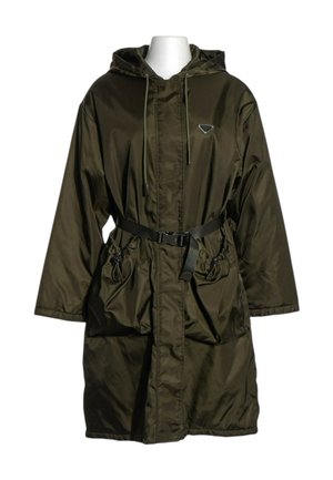 Parka larga de color verde oscuro con capucha, cremallera frontal, cordones ajustables, dos grandes bolsillos delanteros y cinturón negro en la cintura.