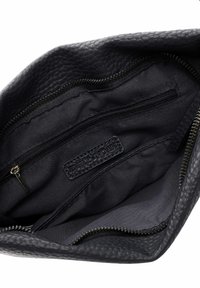 Schwarze, strukturiert Lederetui geöffnet, zeigt schwarzes Stoffinnenfutter mit Reißverschlusstasche und einem eingenähten Etikett.