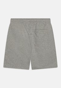 Shorts en coton gris clair avec une taille élastique, dotés d'une poche arrière unique et d'un tissu lisse légèrement texturé.