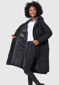 Abrigo acolchado negro con capucha, botones frontales y un bolsillo interior. Material exterior suave con diseño acolchado y forro gris en contraste.