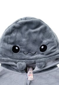 Grau gefütterter Kapuzenpulli mit einer runden Kapuze, die ein lächelndes Gesichtdesign, schwarze Augen und kleine Pom-Pom-Akzente aufweist. Mit Reißverschluss vorne.