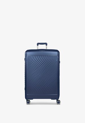 Valise rigide bleue marine avec un design en texture ondulée, une poignée rétractable, quatre roues et une fermeture éclair sur le dessus et le côté.