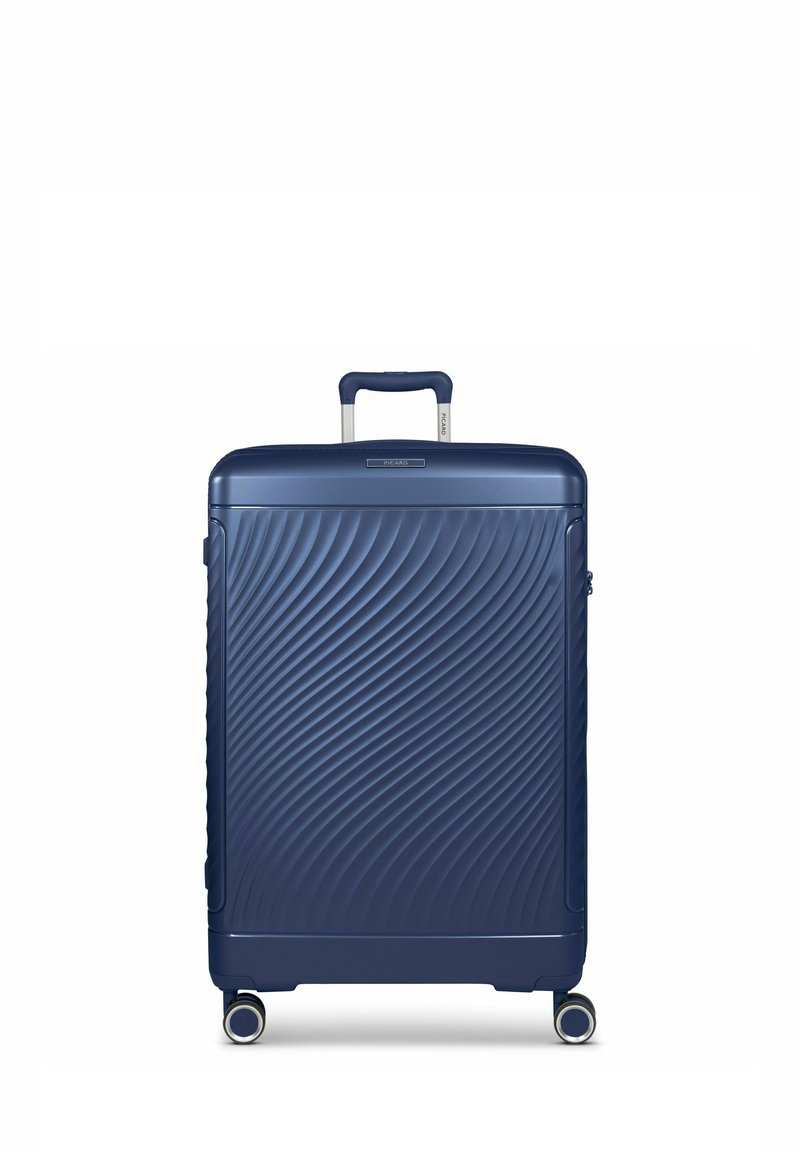 Marineblauwe hard-shell koffer met golvende textuur, uitschuifbare handgreep, vier wielen en een ritssluiting aan de boven- en zijkant.