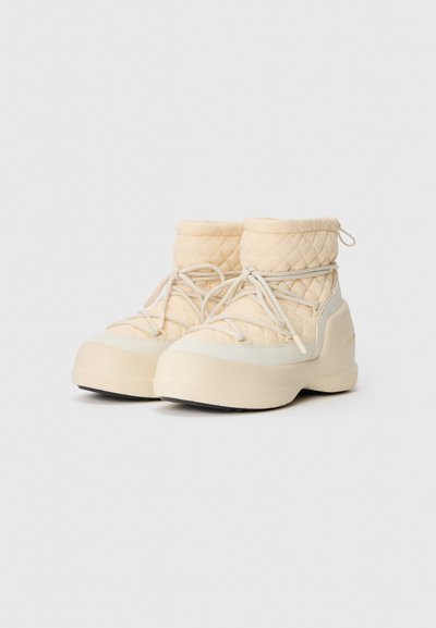 Beige quilted winter boots with thick soles and crisscrossed laces, designed for warmth and outdoor use.