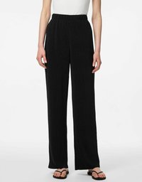 Pantalons larges noirs avec un tissu texturé et une taille élastique, présentant une coupe décontractée et des lignes verticales subtiles.