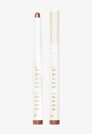 Bobbi Brown cream eyeshadow stick in copper, housed in a white tube with gold accents and starry pattern, featuring a rounded applicator tip.